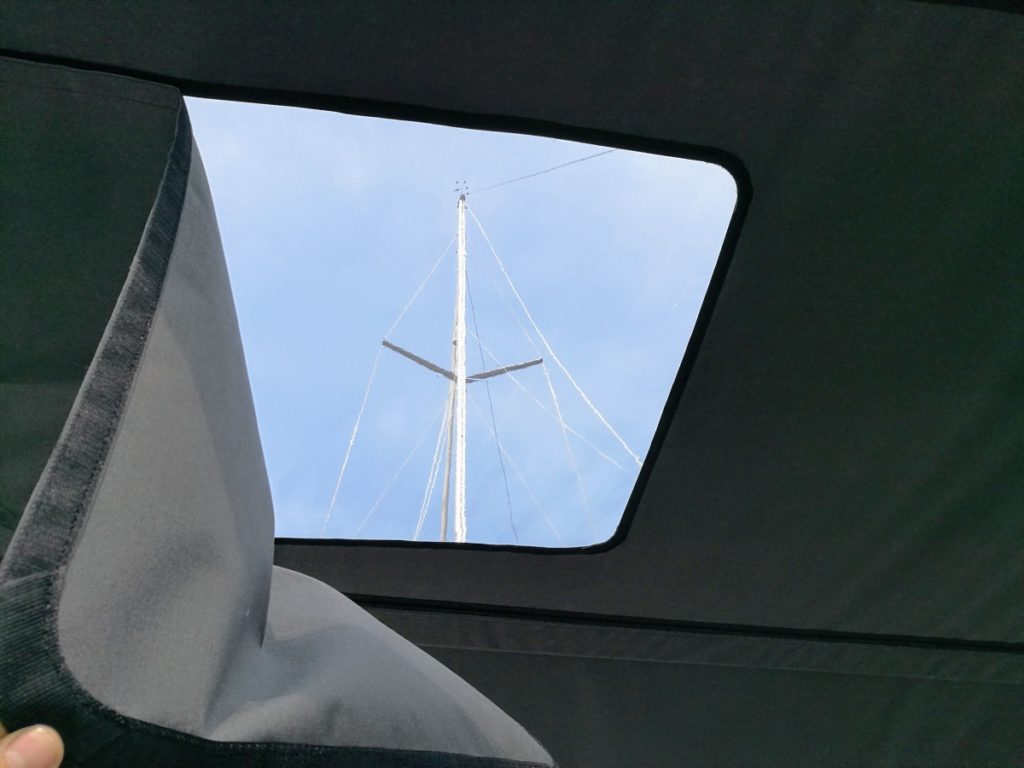 Grijze bimini met raam en blauwe lucht