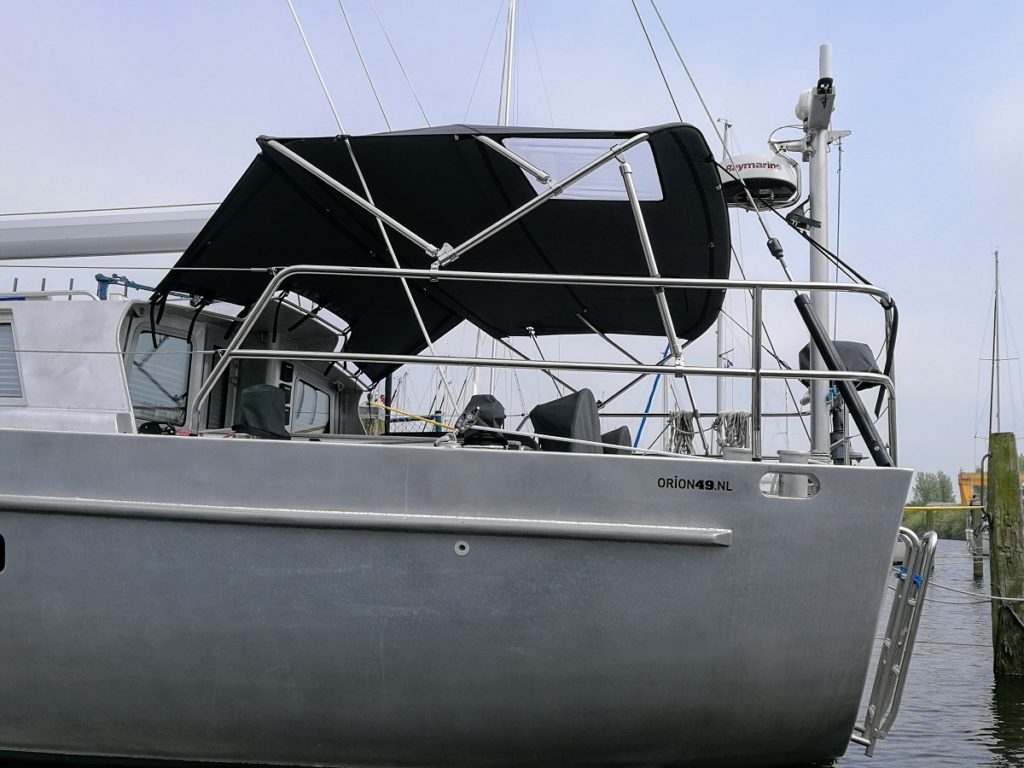 Blauwe bimini op grijze boot in het water